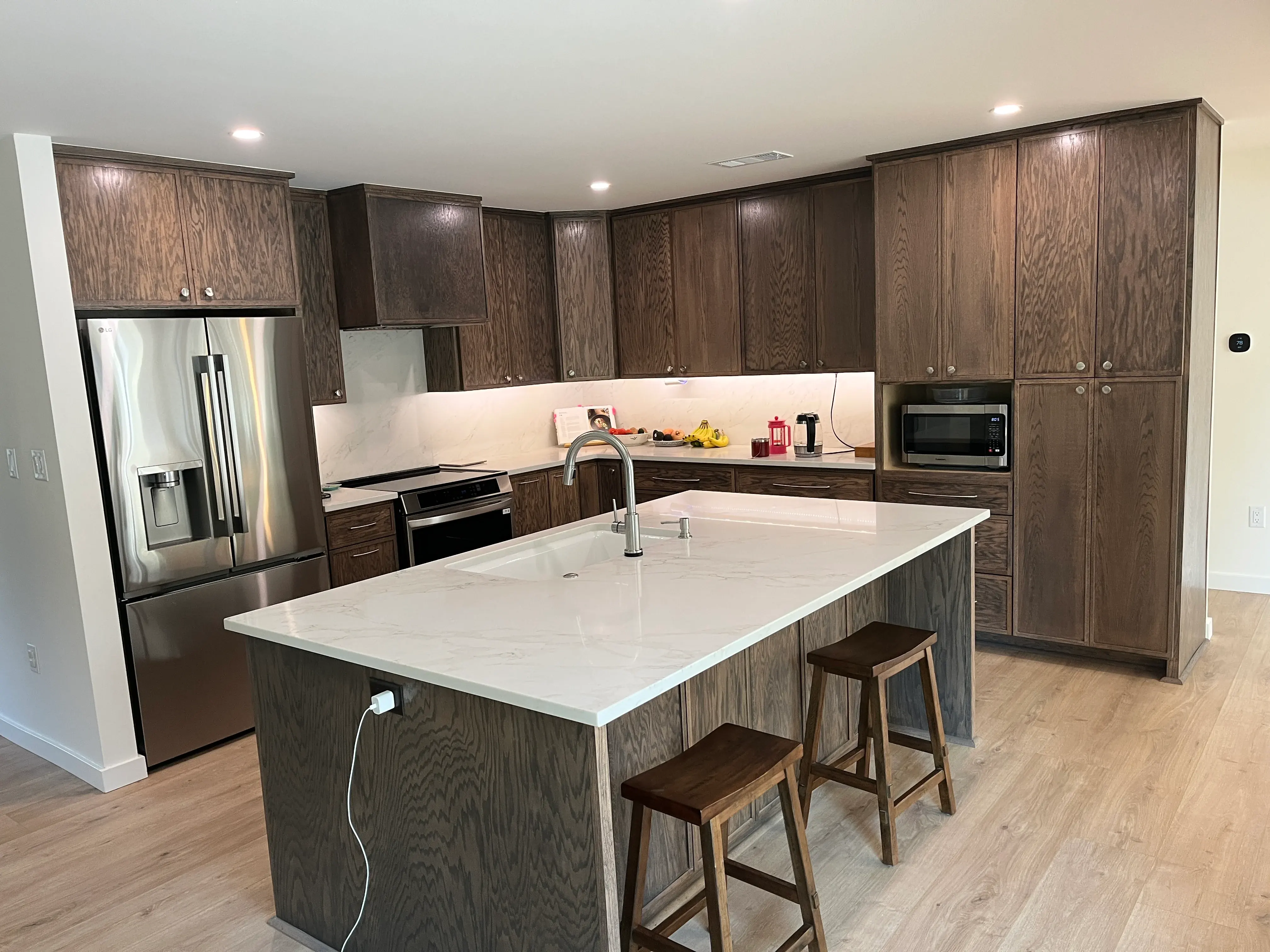 Dark stained oak kitchen with quartz island Fort Smith AR