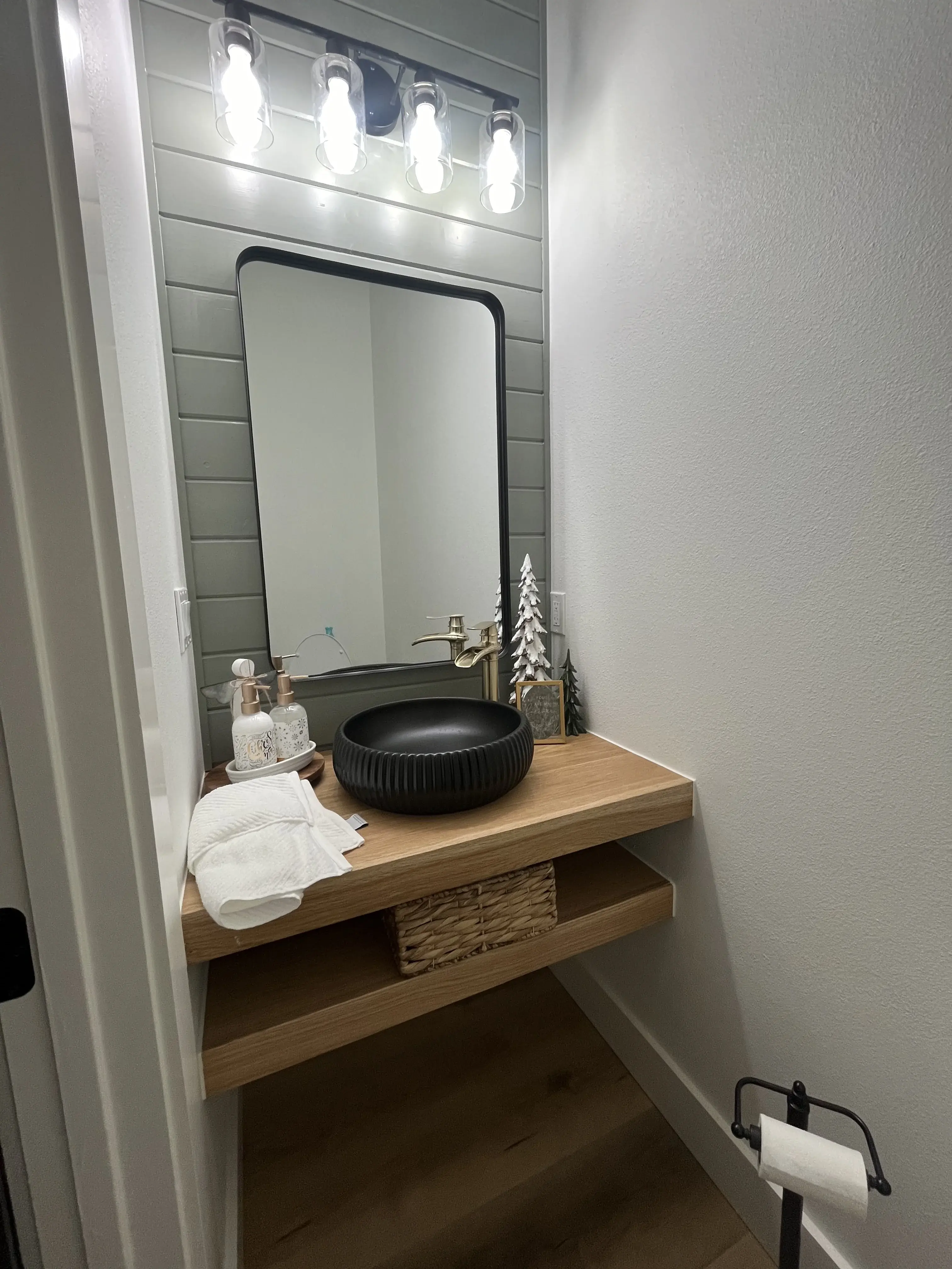 Modern powder room with floating white oak vanity and matte black vessel sink